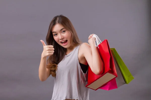 Γυναίκα για ψώνια με τα ψώνια τσάντα και τον αντίχειρα επάνω χέρι σημάδι, καλή sh — Φωτογραφία Αρχείου