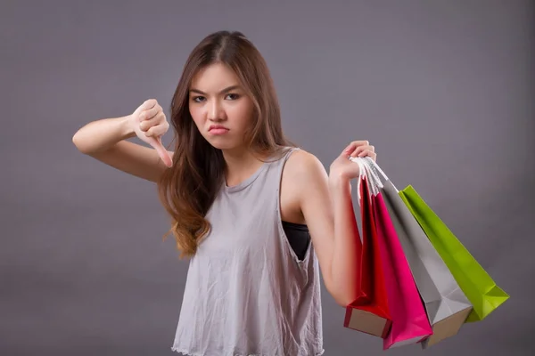 Femme faisant du shopping avec sac à provisions et pouce vers le bas signe de la main, mauvais s — Photo