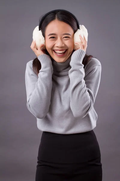 Lyckligt leende asiatisk kvinna med hörselkåpor — Stockfoto