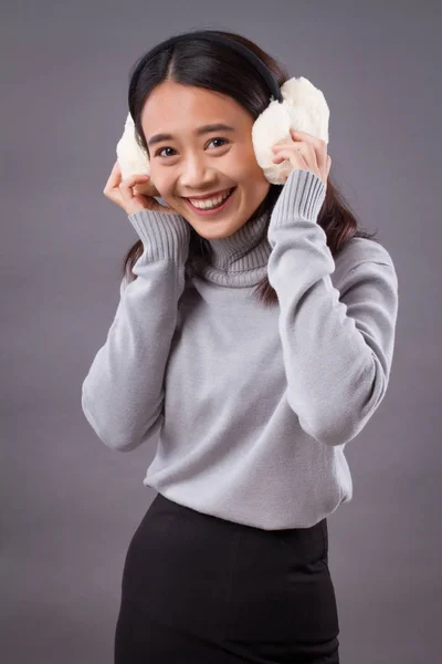 Happy smiling asian woman with earmuffs — Stock Photo, Image