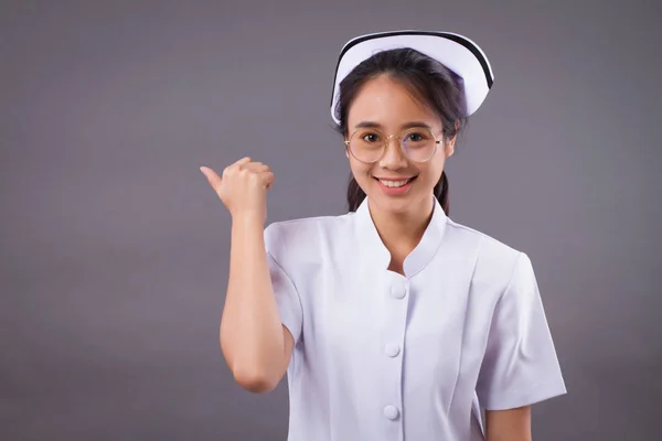 Asiático enfermera apuntando mostrando algo — Foto de Stock
