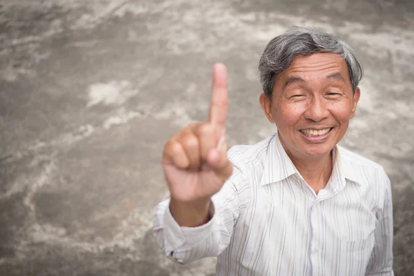 Feliz viejo hombre mayor apuntando hacia arriba 1 dedo — Foto de Stock