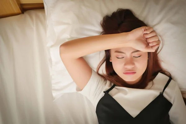 Frunciendo el ceño enfermo cansado mujer inquieta agotada durmiendo con la mano a la frente concepto de enfermedad, dolor de cabeza, resaca, estrés — Foto de Stock