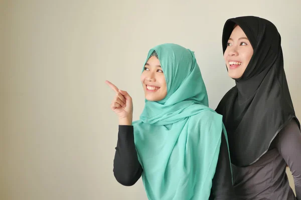Mulher muçulmana feliz, mulheres islâmicas sorridentes apontando para cima; meninas muçulmanas apontam para — Fotografia de Stock