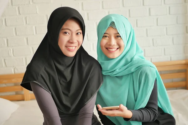 Szczęśliwy islamskie kobiety za pomocą smartfona, uśmiechnięta Azjatka Muzułmanka odtwarzanie smartfon — Zdjęcie stockowe