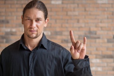 Kafkasyalı adam taş el işaretini işaret ediyor ya da Ana barış elini seviyor.