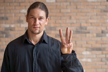 Kendine güvenen beyaz iş adamı 3 parmağıyla işaret ediyor; üçüncü sıra konsepti, 3 puan.