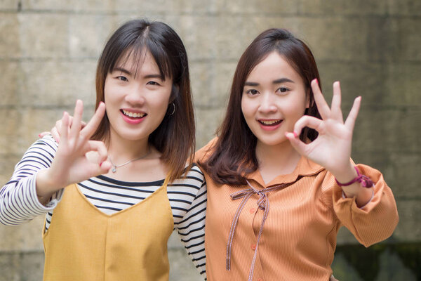 азиатские женщины, одобряющие или одобряющие жест рукой
