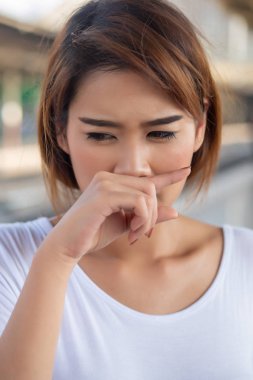 Burnu akan Asyalı kadın; sağlık, vücut bakımı, hastalık, soğuk algınlığı, grip, alerji, ince toz, tozlu hava, kirli hava;