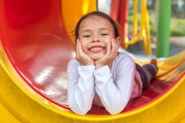 Çocuk parkında oynayan sevimli küçük kız.