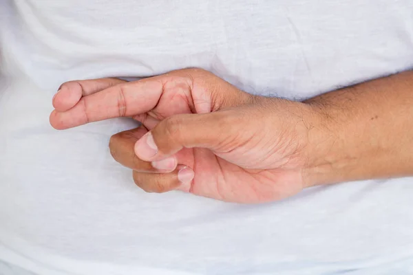 old asian man crossing finger, wishing for good luck