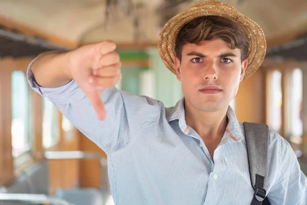 unhappy, angry, upset man traveler giving rejecting thumb down gesture