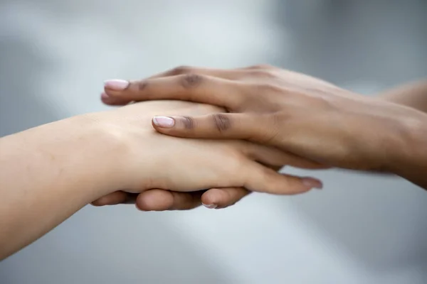 白人女性とアフリカ人女性が手を取り合い握手を交わす 肌の色の寛容 世界平和 民族理解 チームまたはチームワークの概念 — ストック写真