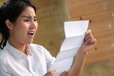 hayal kırıklığına uğramış, şok, pahalı fatura veya borç bildirimi fatura çığlık kadınlar stres; yaşam yüksek maliyet, pahalı bill, bused para kavramı; Asyalı Genç Yetişkin kadın modeli