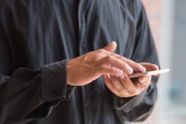 Kafkasyalı iş adamı akıllı telefon kullanıyor; bu akıllı telefon, mobil cihaz teknolojisi konsepti, internet telekomünikasyonu ile çalışan iş adamının eli; genç yetişkin erkek el modu