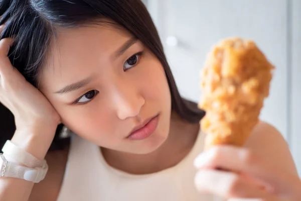 空腹の心配の女性を見て フライドチキンを食べることを躊躇 不健康なおいしい食べ物の概念 健康管理 不健康な食事習慣 フライドチキン — ストック写真