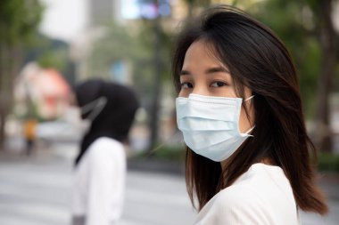 Kirli duman veya virüs salgını ile şehirde maske takan hasta kadın; biyolojik tehlike kavramı, biyolojik tehlike, koruyucu sağlık sistemi, karantina, koronavirüs salgını