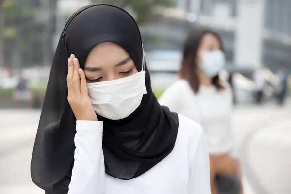 在城市里头戴口罩 头戴肮脏的烟雾的生病的穆斯林妇女 全球暖化 肮脏的空气 空气污染 呼吸困难 喉头酸痛 空气质量差的概念 — 图库照片