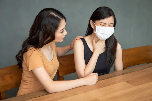 women with friend wearing face mask from fever, flu infection; concept of Wuhan virus, corona virus, H5N1 H1N1, bird flu, pig influenza, pneumonia, lung inflammation, epidemic fever, pandemic outbreak