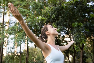 Sağlıklı, mutlu, rahat, parkta genç bir kadın, şehir doğası için kollarını açıyor, çevre için ağaçlar kavramı, hoş bir gün, sağlıklı yaşam tarzı, doğadaki insanlar, temiz hava, kadın yaz yaşam tarzı.