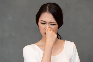 Burnunu kötü kokuya kapatan Asyalı kadın, kötü koku kavramı, kötü nefes, kötü koku, çürük yemek, kötü koku, vücut kokusu; genç yetişkin Çinli Asyalı kadın model