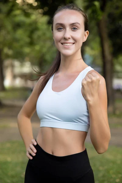 healthy happy strong fitness woman works out; concept of woman with healthy lifestyle, health care, body care, confident fitness people in fresh air and green environment; white caucasian woman model