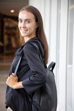 mutlu gülümseyen kızın portresi omuzlarının üzerinden geriye bakıyor; pozitif rahatlamış mutlu beyaz beyaz kadın portresi gülümsüyor ve size bakıyor; genç yetişkin beyaz kadın model