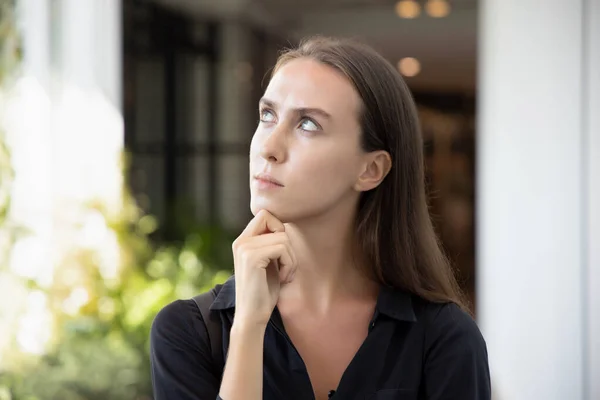 stressed upset thoughtful white caucasian woman thinking, planning about problem; portrait of woman looking up, thinking, finding good idea or decisive plan; young adult Russian caucasian woman model