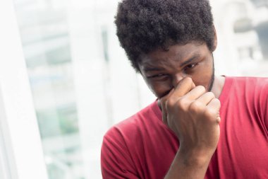 Virüs salgını nedeniyle burnu akan hasta adam; biyolojik tehlike, sağlık bakımı, hastalık karantinası, koronavirüs salgını kontrolü, hastalık önleme, COVID-19, fiziksel ya da sosyal mesafe