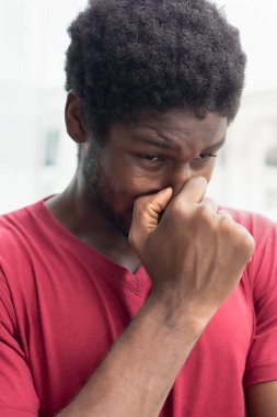 Virüs salgını nedeniyle burnu akan hasta adam; biyolojik tehlike, sağlık bakımı, hastalık karantinası, koronavirüs salgını kontrolü, hastalık önleme, COVID-19, fiziksel ya da sosyal mesafe