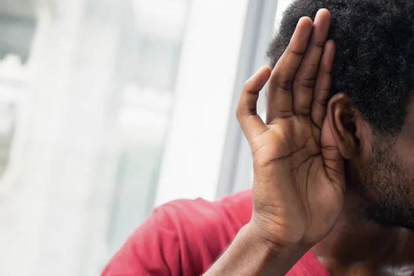 伤心而沮丧的非洲黑人听坏消息或听力受损的非洲黑人听坏消息或听力受损的非洲黑人治疗耳朵的概念 助听器 假新闻非洲黑人模型 — 图库照片
