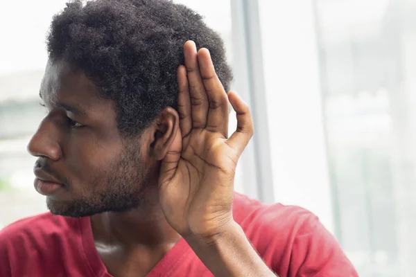 悲しい不満を抱えたアフリカ系黒人男性が悪いニュースを聞いているか 聞こえにくい 聞こえにくい 耳薬の概念 補聴器 偽のニュース アフリカ系黒人男性モデル — ストック写真