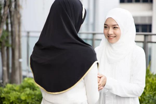 Muslim woman or Muslimah greeting with hand shake; Concept of Islamic greeting by woman, religion of peace, Ramadan, Salam, As-salamu alaykum, Peace be upon you; Asian Muslim young adult woman model