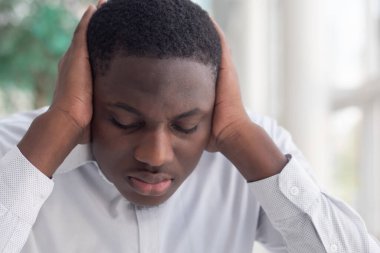 Afrikalı siyahi adam kulaklarını kapatıyor; sansür, konuşma özgürlüğü kısıtlaması, haber manipülasyonu, gizli gerçek, gizli bilgi manipülasyonu, sorun örtbas etme