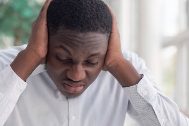 Afrikalı siyahi adam kulaklarını kapatıyor; sansür, konuşma özgürlüğü kısıtlaması, haber manipülasyonu, gizli gerçek, gizli bilgi manipülasyonu, sorun örtbas etme