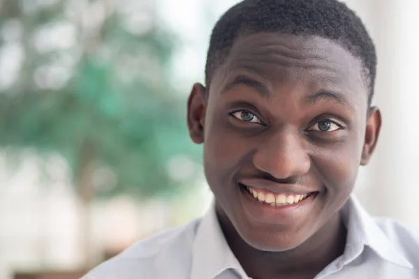 Happy smiling African black man; portrait of optimistic friendly African black man with positive smiling face expression