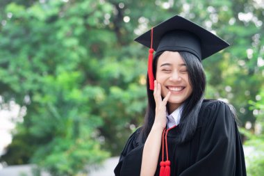 Mutlu gülümseyen üniversite mezunu; başarılı eğitim kavramı, mutlu diploma günü, kadın eğitim eşitliği, iş fırsatı, yüksek öğrenim diploması, denizaşırı burslar