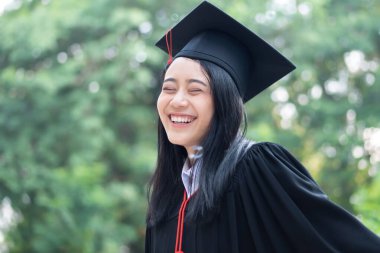 Mutlu gülümseyen üniversite mezunu; başarılı eğitim kavramı, mutlu diploma günü, kadın eğitim eşitliği, iş fırsatı, yüksek öğrenim diploması, denizaşırı burslar