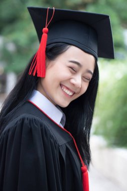 Yükselen mutlu gülümseyen üniversite öğrencisi konsepti; başarılı eğitim, mutlu diploma günü, kadın eğitim fırsatı, mezuniyet, eğitim vizyonu, denizaşırı burslar