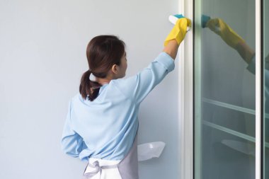 Asyalı kadın evi temizliyor, Duster 'la ev işi yapıyor.