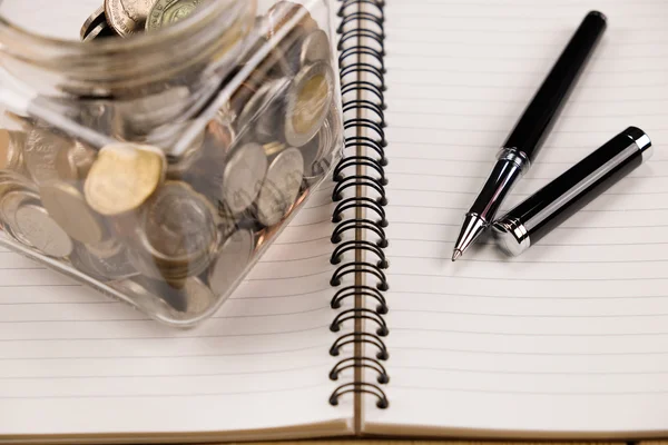A person meticulously filling out a spreadsheet on a laptop, surrounded by financial documents.