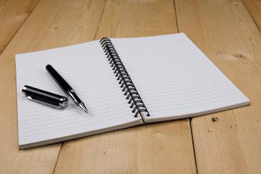 kalem ve kitap ahşap arka plan üzerinde