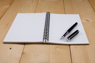 kalem ve kitap ahşap arka plan üzerinde