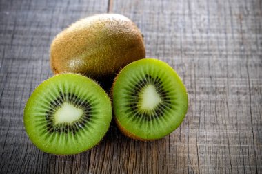 Sağlıklı kivi meyve ve ahşap masa arka plan üzerine dilimlenmiş taze yeşil