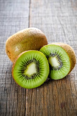 Sağlıklı kivi meyve ve ahşap masa arka plan üzerine dilimlenmiş taze yeşil