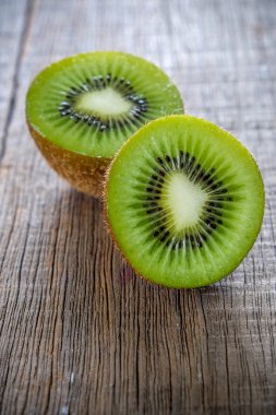Sağlıklı kivi meyve ve ahşap masa arka plan üzerine dilimlenmiş taze yeşil