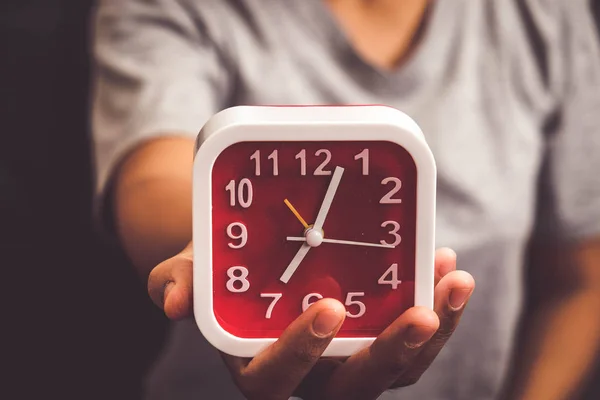 Mão segurando relógio de alarme com efeito de filtro estilo vintage retro — Fotografia de Stock