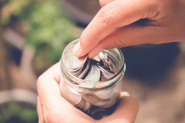 сэкономить деньги для инвестиционной концепции Рука держит деньги в банке с эффектом фильтра ретро винтажный стиль
