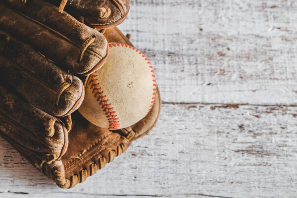 old Baseball and glove on wood background with filter effect retro vintage style