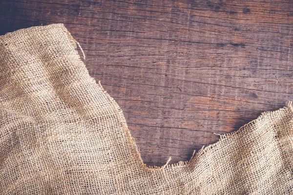 Wood table with old sackcloth burlap tablecloth texture with filter effect retro vintage style — Stock Photo, Image